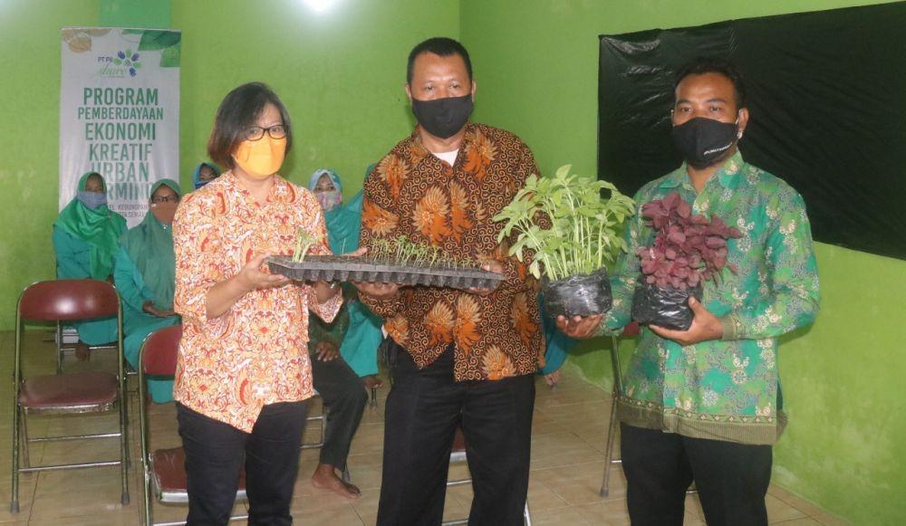 Direktur Tiga Langkah, Suharti Sadja, menyerahkan berbagai bibit sayuran kepada warga RW 04, Kelurahan Kedungpane, Kecamatan Mijen, Kota Semarang pada Program Pemberdayaan Ekonomi Kreatif Urban Farming. (dok. Tiga Langkah)