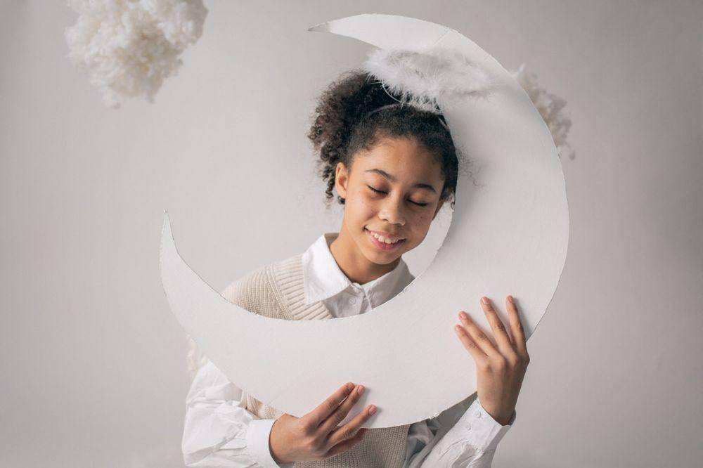 Seorang anak perempuan memegang bulan sabit buatan (pexels.com/Monstera)
