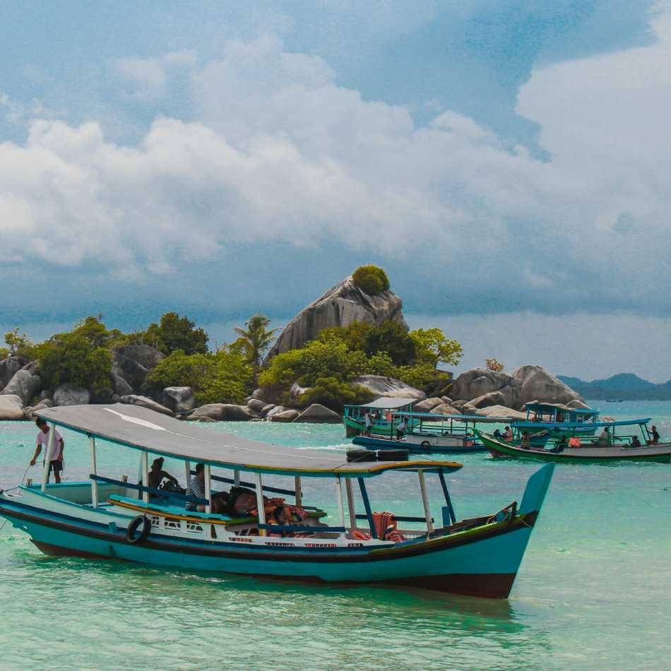 Naik kapal di pulau (unsplash.com/alfianostn)