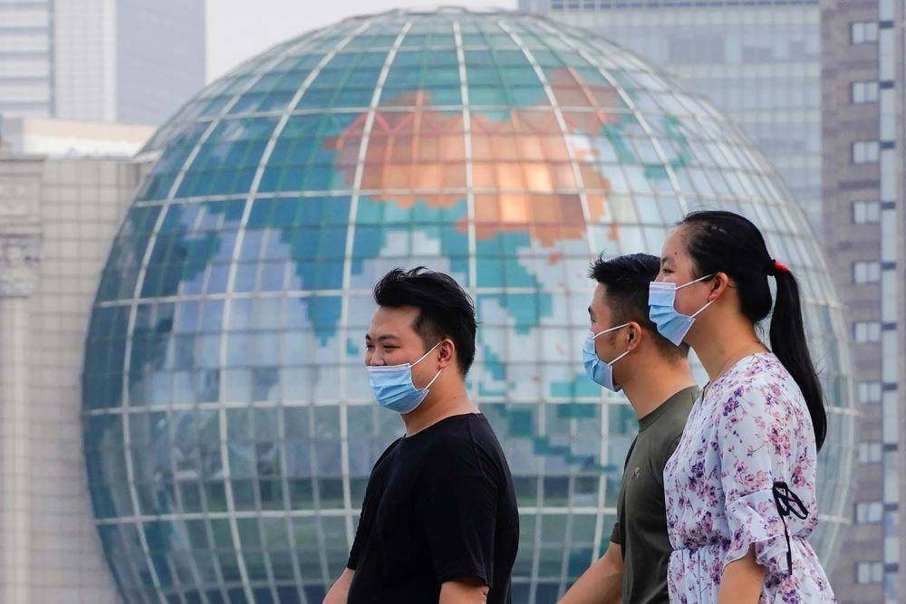 Warga memakai masker pelindung berjalan di sepanjang The Bund di depan distrik keuangan Lujiazui Pudong, menyusul kasus baru penyakit virus korona (COVID-19) di Shanghai, China, Rabu (25/8/2021) (ANTARA FOTO/REUTERS/Aly Song)