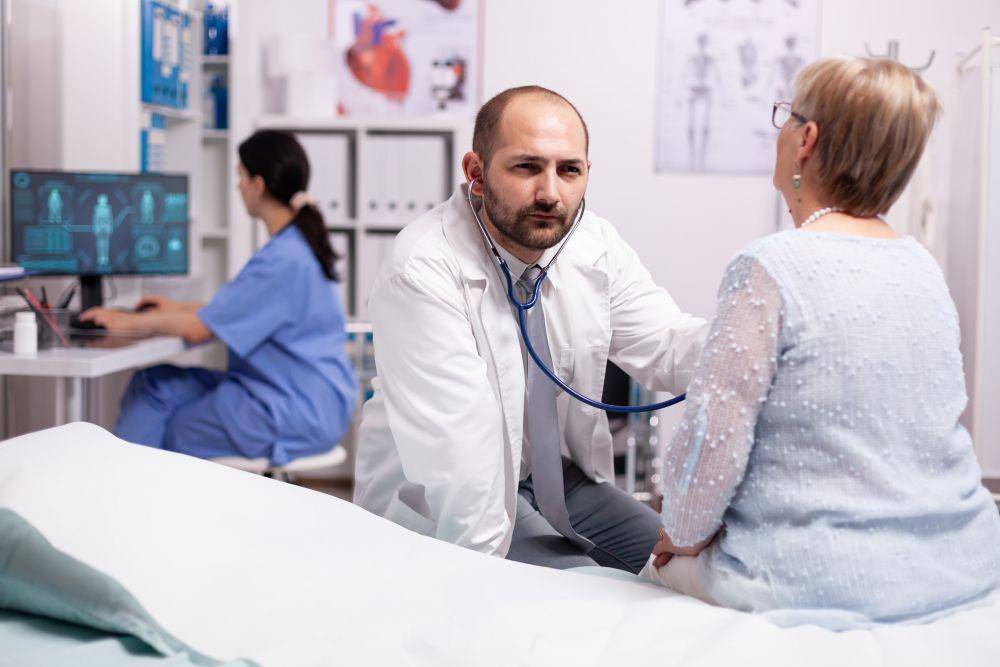 ilustrasi dokter memeriksa pasien dengan stetoskop (freepik.com/DCStudio)