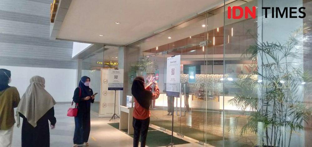 Pengunjung melakukan scan barkot peduli lindungi sebelum masuk area bioskop (IDN Times/Silviana)