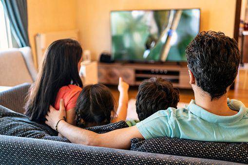 ilustrasi sebuah keluarga yang sedang menonton TV (Getty Images/Phynart Studio)