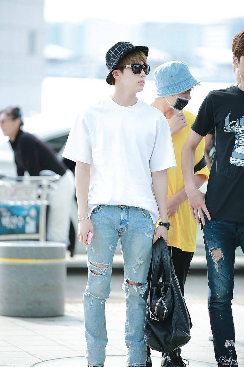 Jin BTS mengenakan kaus dan celana jeans (koreaboo.com)