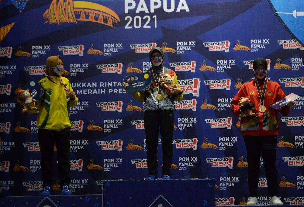 Peraih medali emas anggar putri dari Riau Nisa Aprawasih (tengah) berfoto bersama peraih medali perak anggar Anis Rohadatul Niehlah Riyati (kiri) dan peraih medali perunggu anggar A. Almaidah Dirhamzah (kanan), pada nomor Degen Individual Putri PON XX Papua 2021, di Archelaus Sai, Komplek Gereja ST Yoseph, Merauke, Papua, Selasa (5/10/2021).