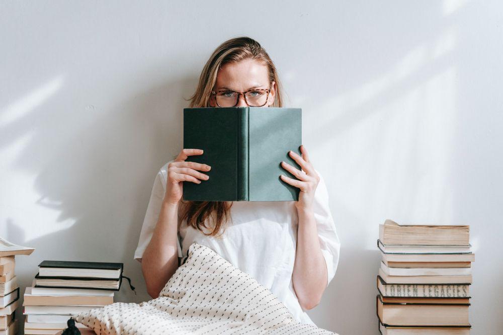 ilustrasi menutup muka dengan buku (pexels.com/George Milton)
