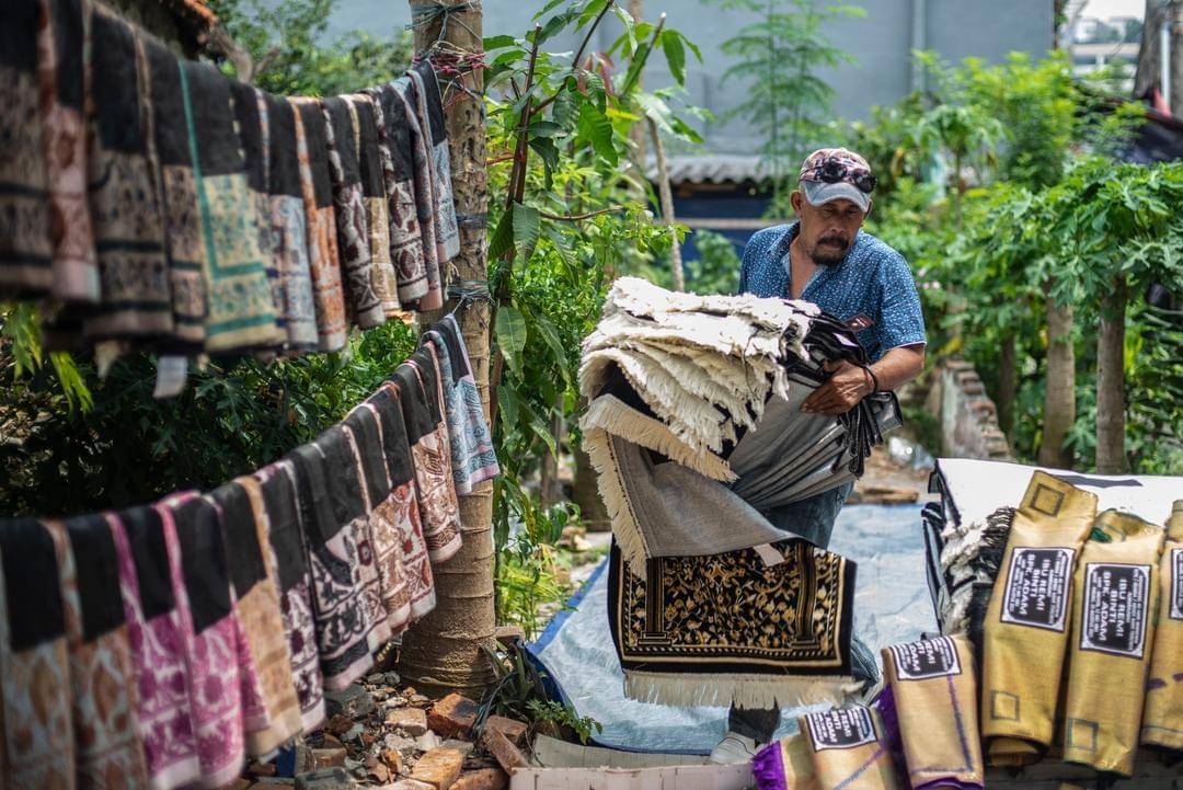Pekerja mengangkat sajadah yang telah disablon di kawasan Kebon Melati, Jakarta, Rabu (29/9/2021).