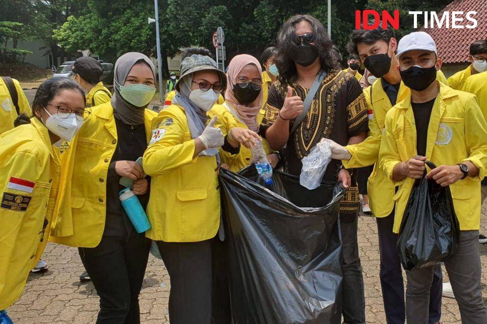 Mahasiswa UI membersihkan sampah saat unjuk rasa yang mereka lakukan di Kampus UI Depok pada Selasa (12/10/2021). (IDN Times/Dicky)