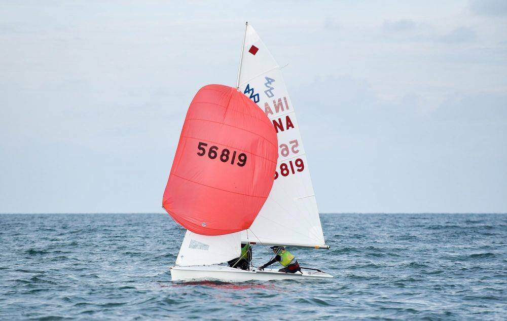 Cabor Layar di Class Int 420 Putri,Dia Tri Utami dan Nur Fatin Syafika peselancar asal Kalimantan Timur, Sail No INA 56819 menjadi rangking pertama di Pantai Hamadi TNI AL Jayapura Papua, Senin (11/10/2021). (Foto: PB PON XX PAPUA/Yustha Coritha.)