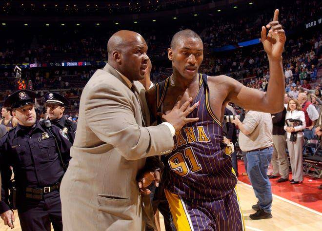 Ron Artest diamankan keluar lapangan pada kejadian Malice at The Palace. (detroitnews.com)