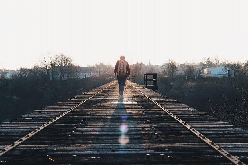 potret seseorang yang sedang berjalan di atas rel kereta api (unsplash.com/Dan Gribbin)