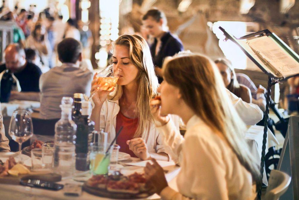 ilustrasi dua wanita sedang makan (pexels.com/Andrea Piacquadio)