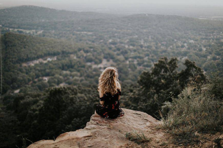 potret wanita yang sedang berada di atas tebing sendirian (unsplash.com/Hannah Busing)