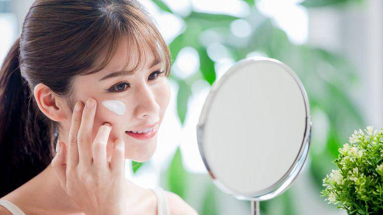 Ilustrasi perempuan menggunakan sunscreen (thelist.com/418258)