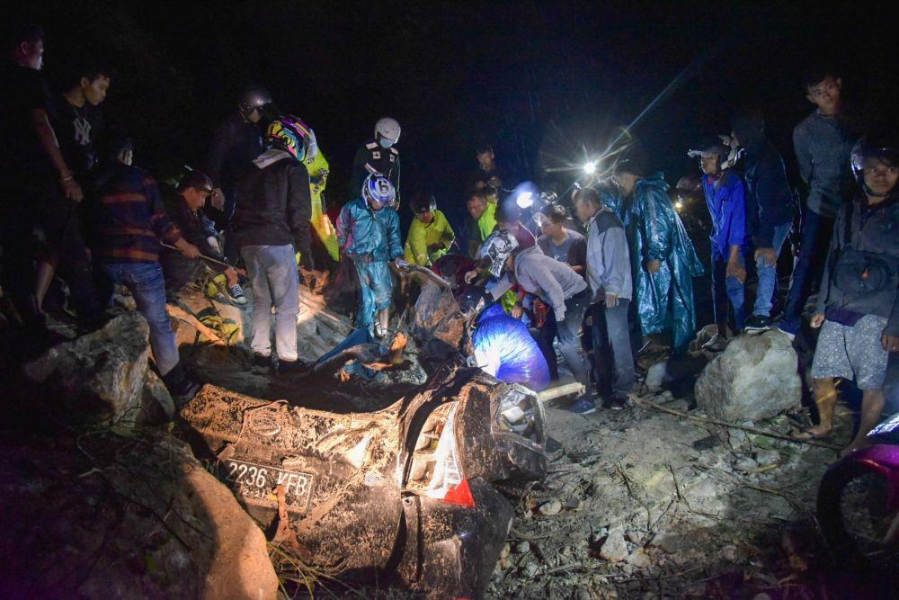 Warga berusaha mengevakuasi korban longsor yang selamat di kawasan tikungan PDAM Tirtanadi, Sibolangit, Deli Serdang, Sumatera Utara, Sabtu (23/10/2021) malam. (ANTARA Foto/Fransisco Carolio)