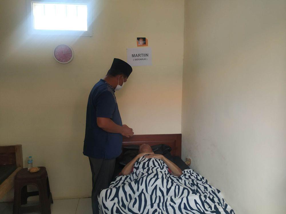 Petugas saat memeriksa salah satu penghuni yang mengalami stroke dan diserahkan oleh keluarganya untuk dirawat. IDN Times/Alfi Ramadana