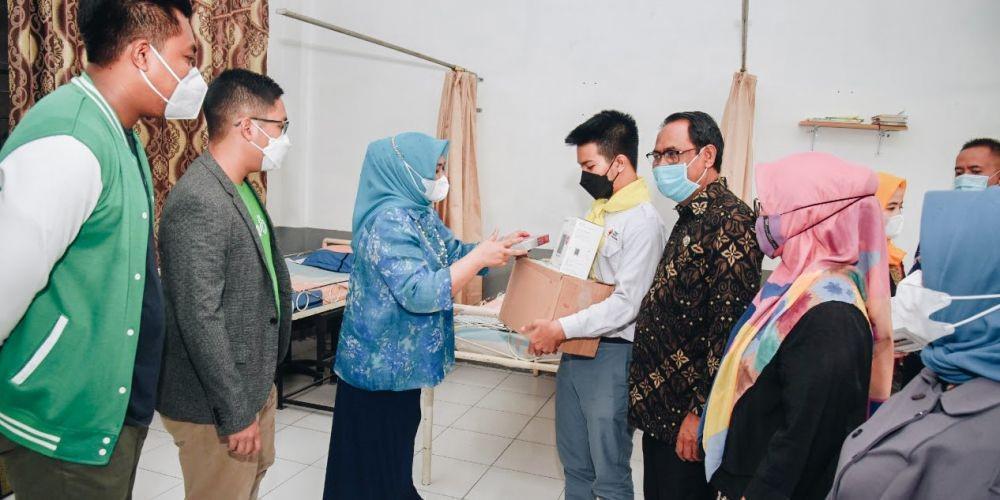 Ketua TP PKK Provinsi Sumatera Utara, Nawal Lubis bersama Region Manager of North-South Sumatera, Grab Indonesia, Gusti Sartono tengah memberikan bantuan paket berupa alat sekolah dari kampanye “BERSATU Untuk Indonesia” kepada salah satu siswa di SMA Negeri di Sumatera Utara (Dok. IDN Times)