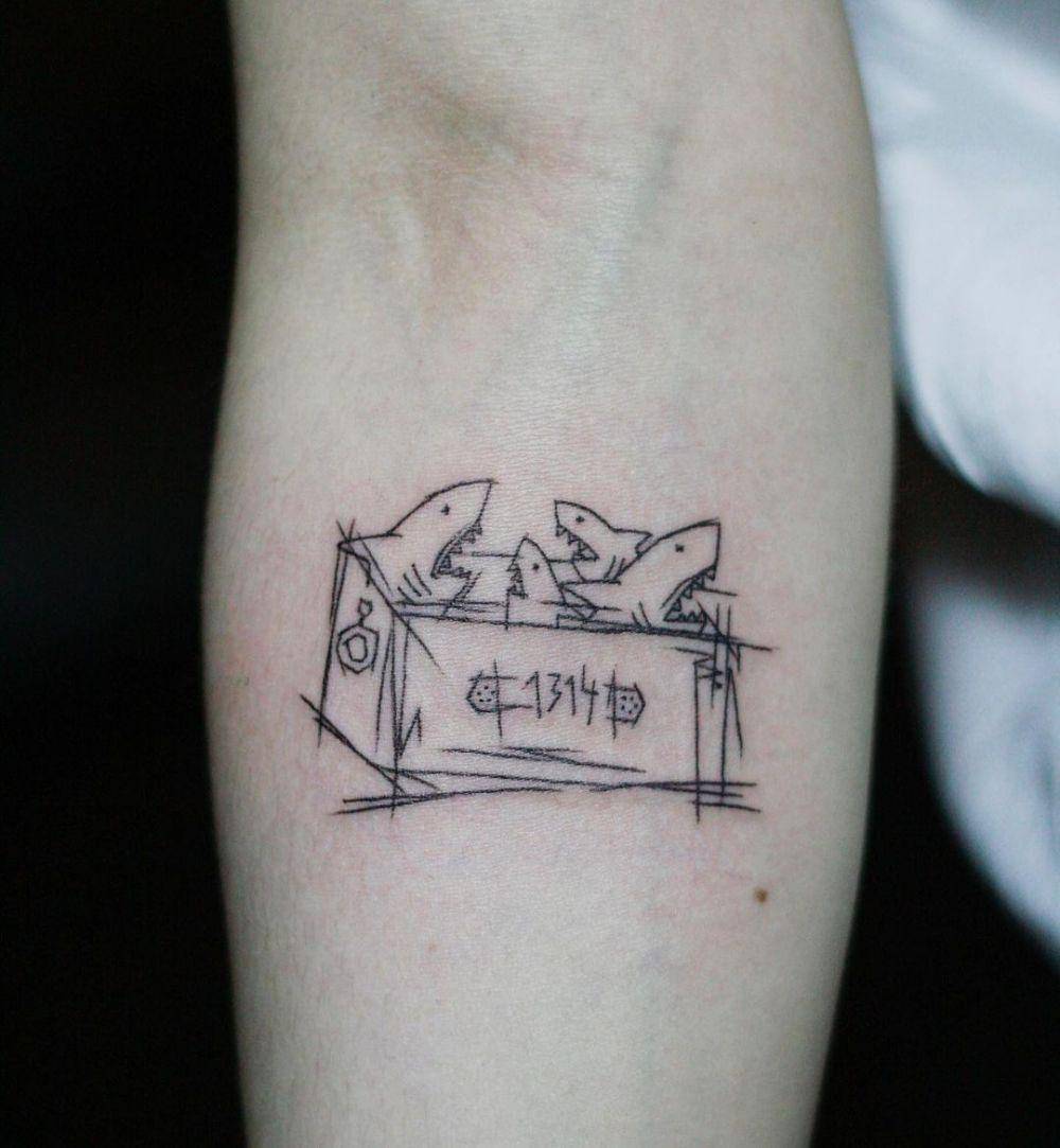 desain tato ikan hiu mainan di dalam box (instagram.com/coreatattoo)
