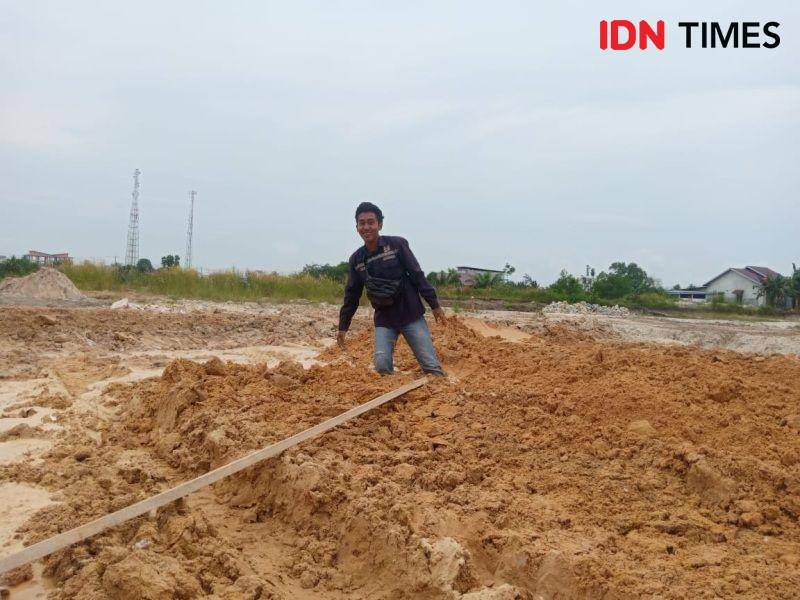 Seorang pekerja UPT PU Babulu menujukan kondisi tanah lahan jalan lingkar pasar yang lembek (IDN Times/Ervan)
