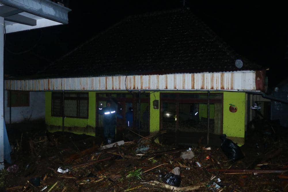 Petugas sedang melakikan evakuasi disalah satu rumah terdampak banjir bandang. IDN Times/Alfi Ramadana