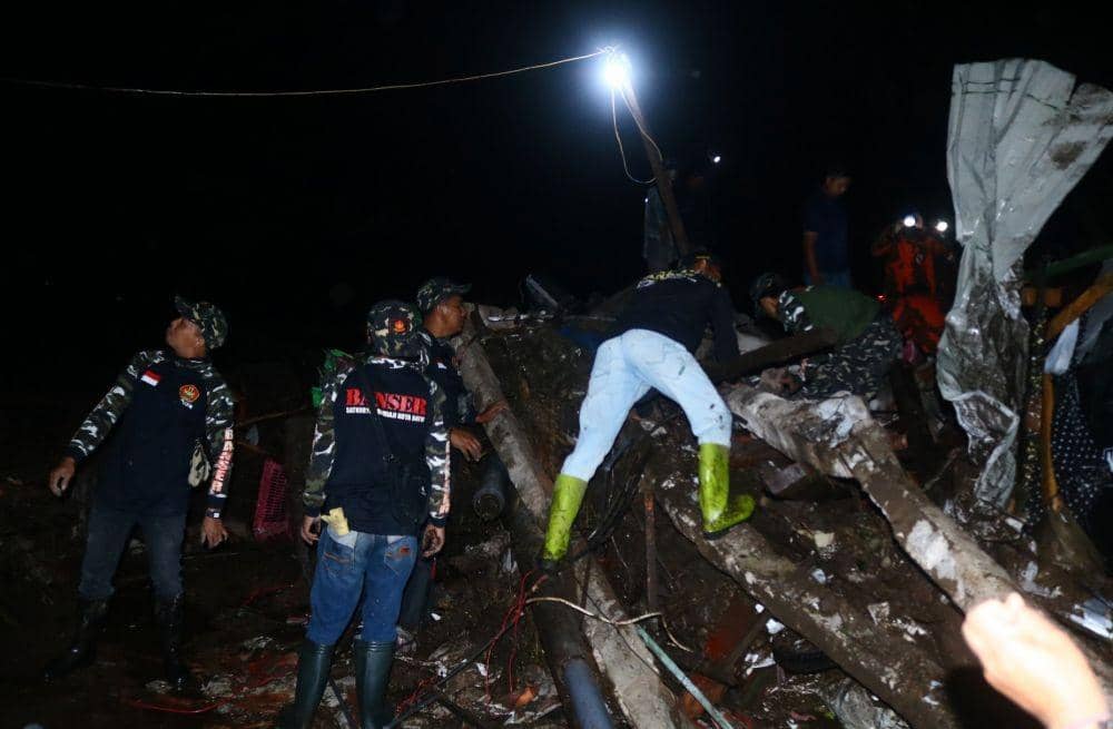 Petugas membersihkan puing-puing reruntuhan pasca banjir bandang. IDN Times/Alfi Ramadana