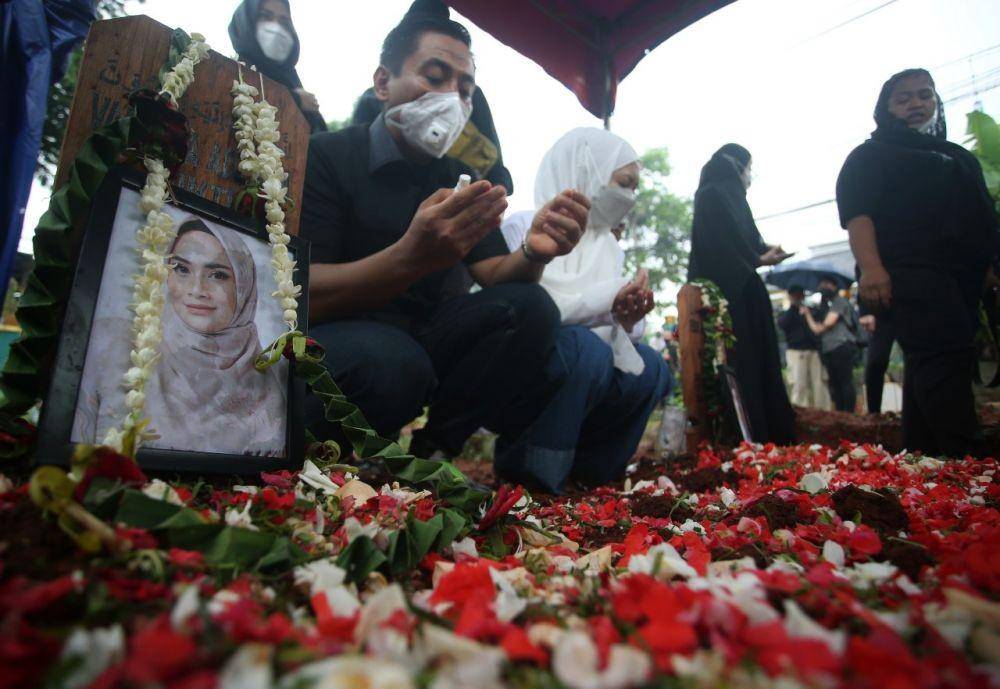 Keluarga dan warga berdoa di pusara Vanessa Angel dan suaminya Febri Andriansyah usai pemakaman di TPU Islam Malaka, Pesanggrahan, Jakarta, Jumat (5/11/2021). (ANTARA FOTO/Muhammad Iqbal)
