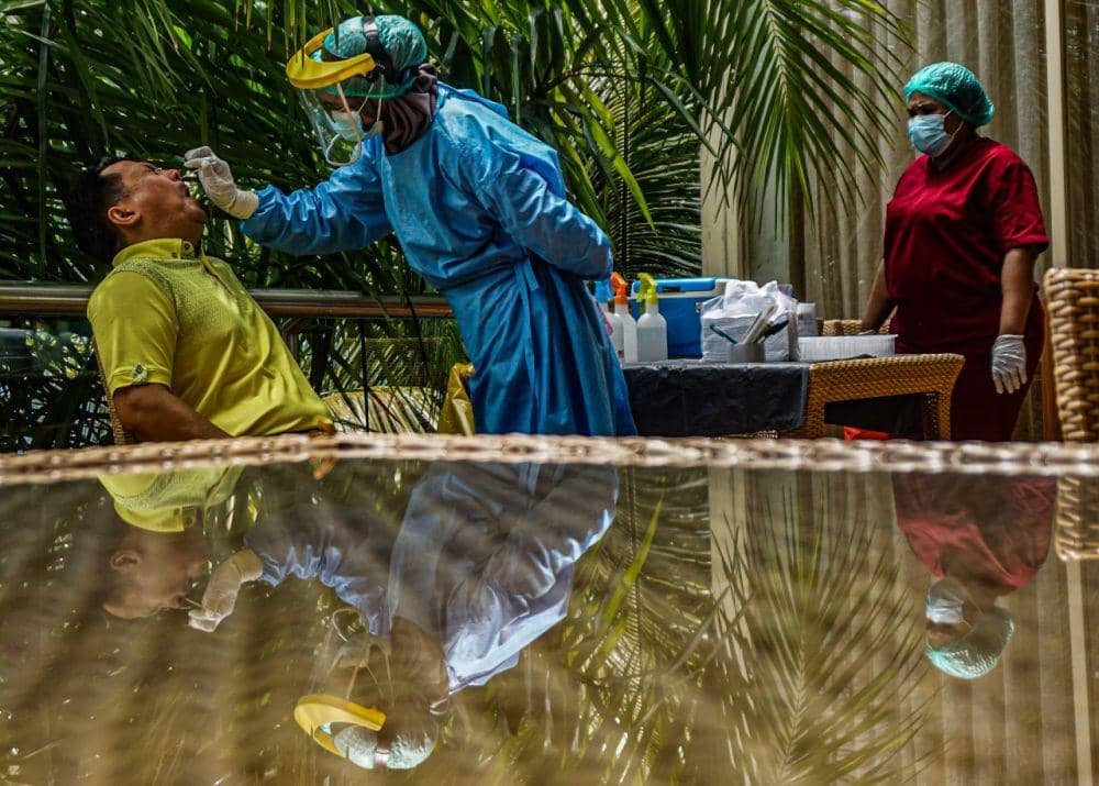 Petugas medis Labkesda Papua mengambil sampel untuk tes usap RT Polymerase Chain Reaction (PCR) kepada tamu undangan di Swiss-Bellhotel Hotel Jayapura, Papua, Jumat (5/11/2021). ANTARA FOTO/Indrayadi TH.