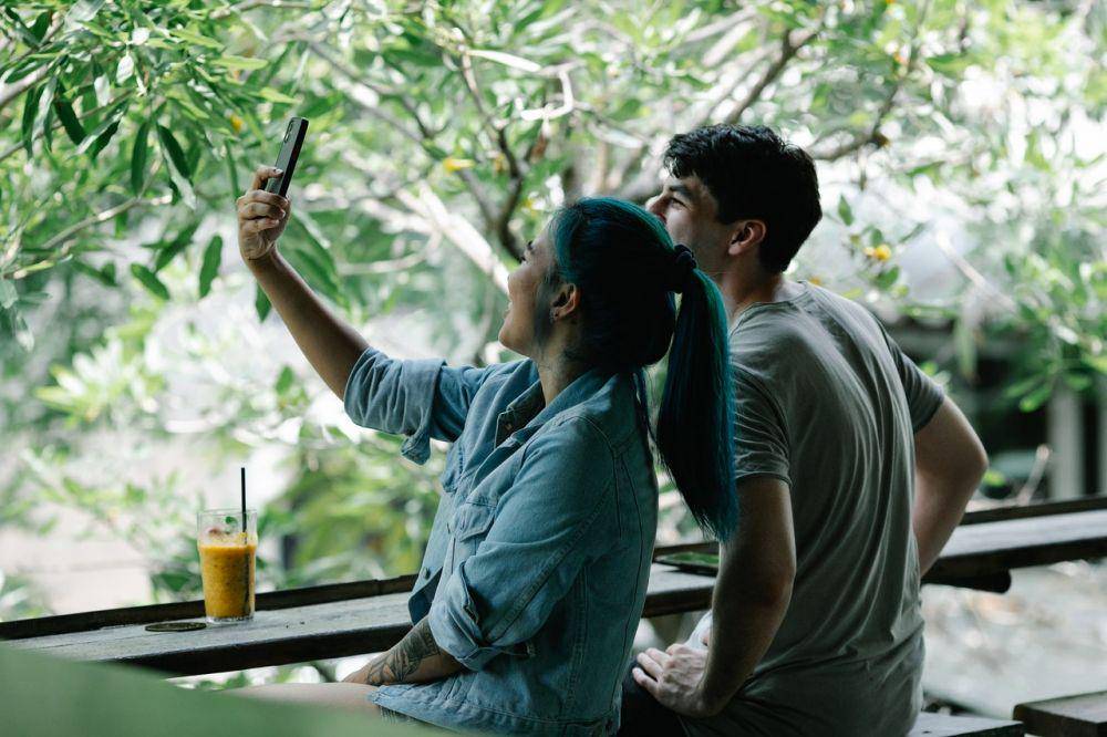 Pasangan mengambil selfie di teras. (pexels.com/GeorgePak)