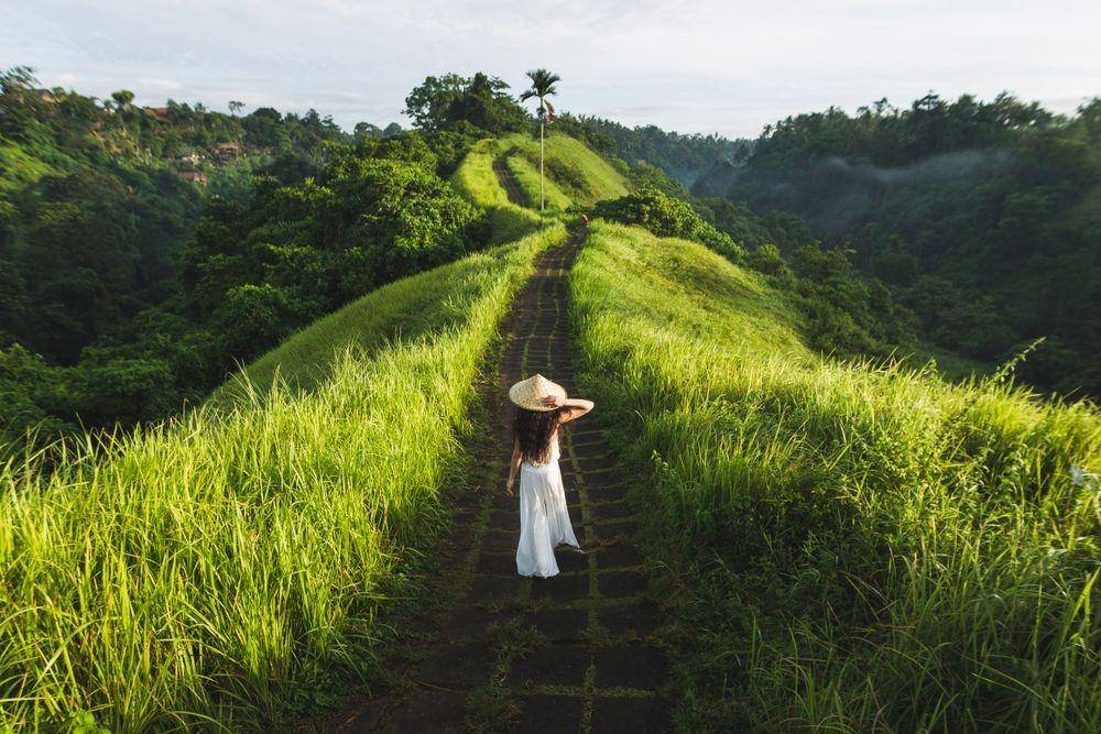 Seorang perempuan tengah berjalan di Campuhan Ridge Walk (ShutterStock/ReslavtsevOleg)