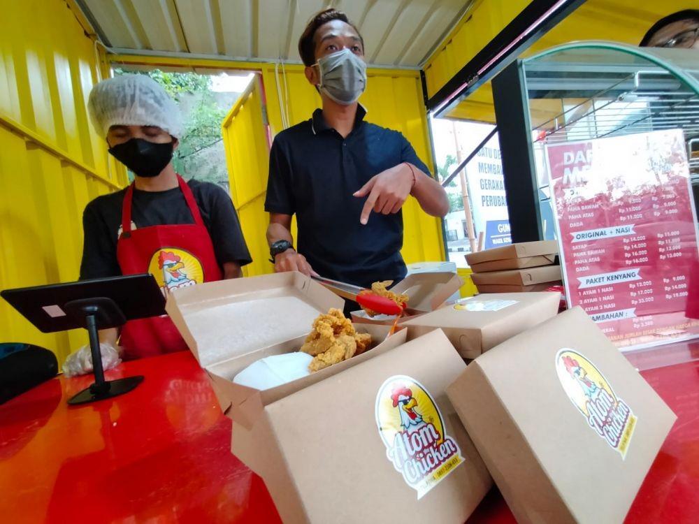 Fery Rizkiawan, saat melayani pembeli di gerai ayam goreng miliknya. Dok. Istimewa.