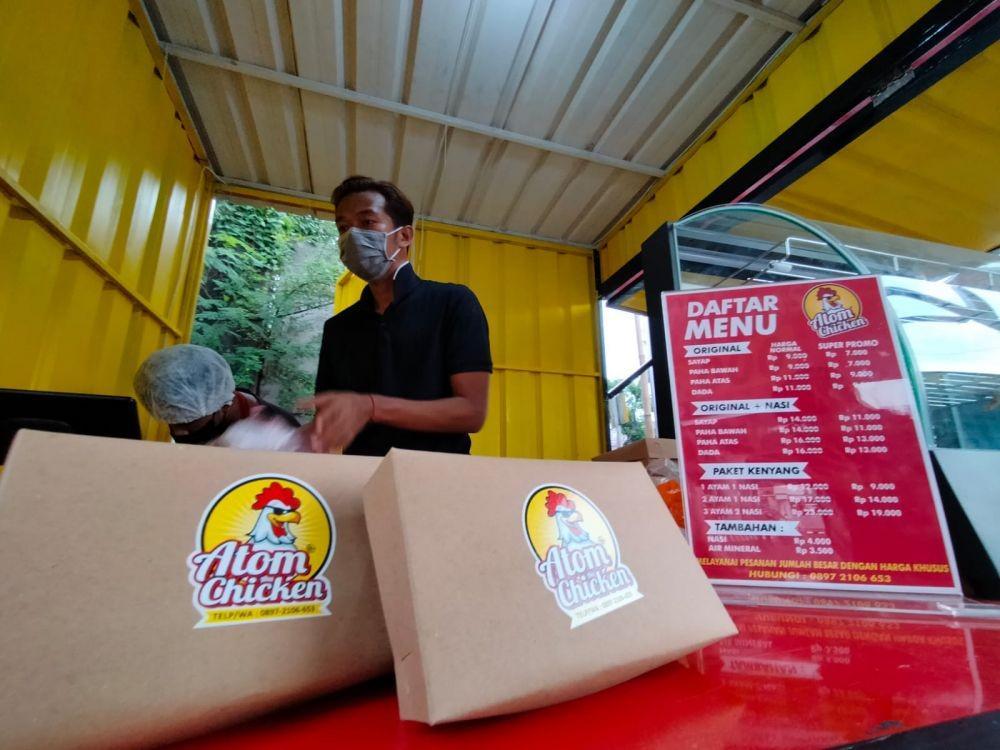 Fery Rizkiawan, saat melayani pembeli di gerai ayam goreng miliknya. Dok. Istimewa.
