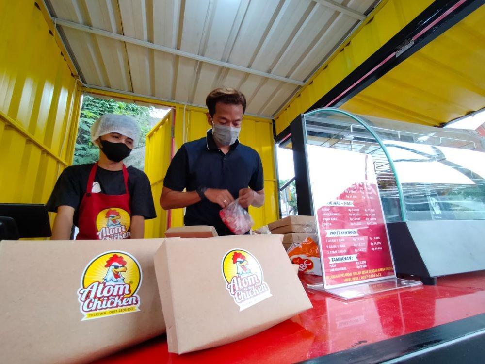 Fery Rizkiawan, saat melayani pembeli di gerai ayam goreng miliknya. Dok. Istimewa.