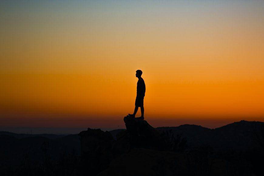potret seseorang yang berada di atas batu sendirian (unsplash.com/Austin Mabe)