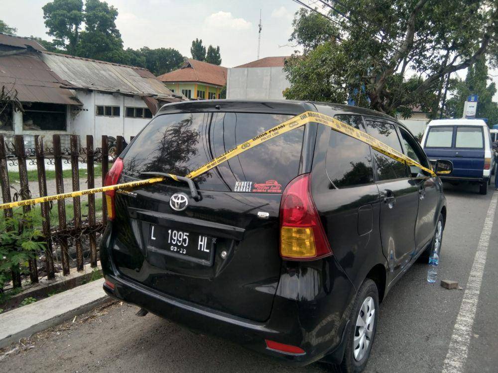 Polisi memasang police line di mobil korban. IDN Times/Zainul Arifin