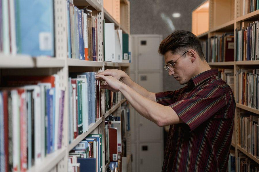 ilustrasi orang sedang memilih buku (pexels.com/Tima Miroshnichenko)
