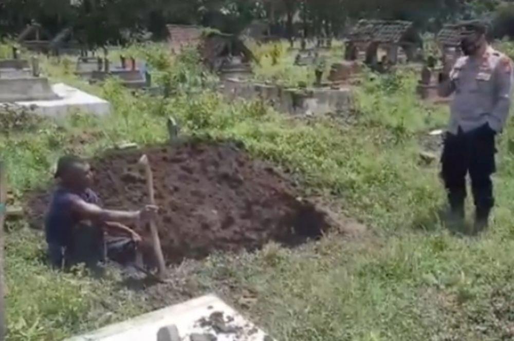 Petugas polisi membujuk warga yang membongkar makam istrinya di Ponorogo. Dok.IDN Times/Istimewa