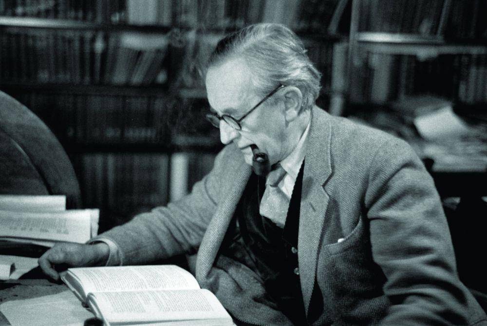 J.R.R. Tolkien membaca buku di ruang kerjanya, 1955. (newsweek.com/Haywood Magge)