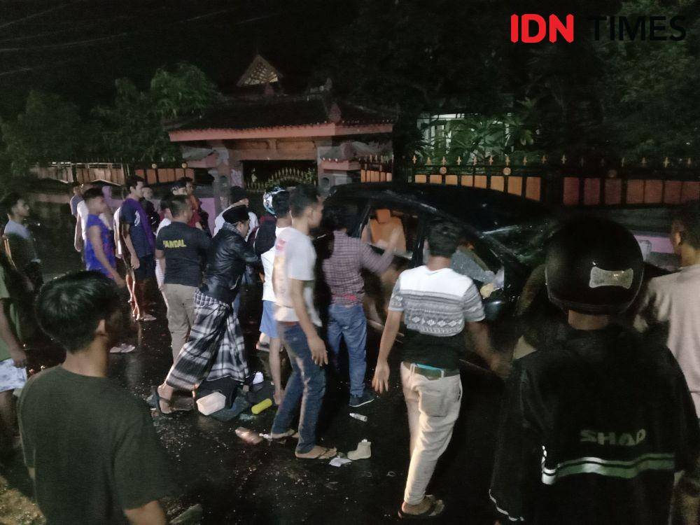Warga ramai-ramai bantu membalikkan badan mobil IDN Times/Ahmad Viqi