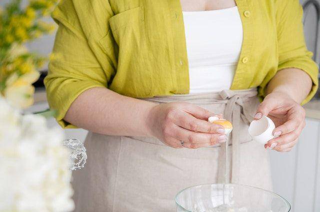 Wanita sedang memisahkan putih dan kuning telur. (pexels.com/shvets-production)