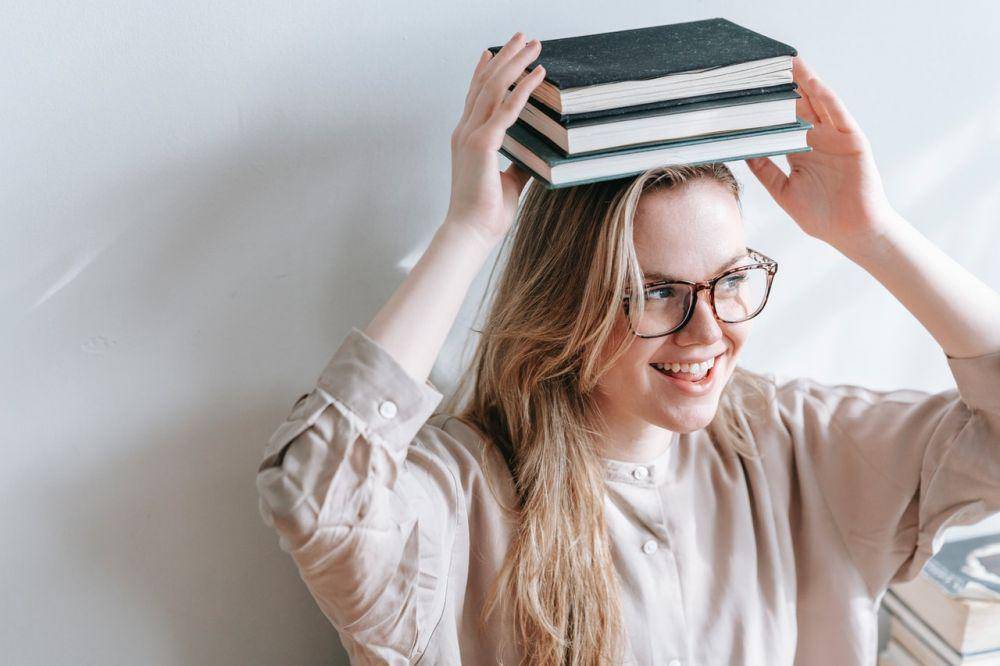 ilustrasi membawa setumpuk buku (pexels.com/George Milton)