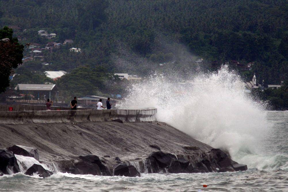 Sejumlah warga menyaksikan terjangan ombak di tepi Pantai Teluk Manado, Sulawesi Utara, Rabu (8/12/2021). (ANTARA FOTO/Adwit B. Pramono)