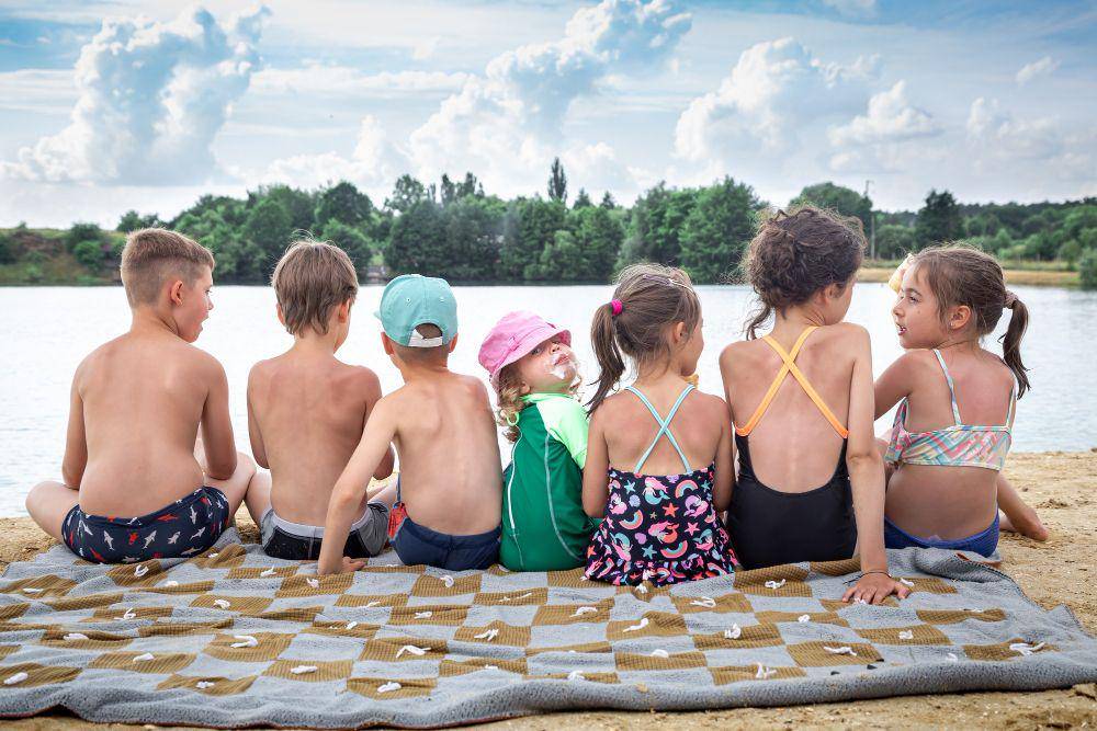 ilustrasi anak-anak berjemur di pantai (freepik.com/pvproductions)