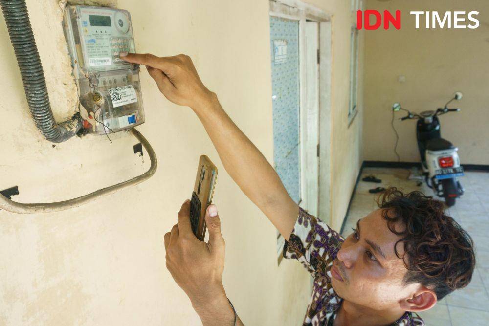 Anis Ramadhani (27), driver ojek online mengisi token listrik melalui aplikasi layanan perbankan di rumahnya di Kalasan, Sleman, Daerah Istimewa Yogyakarta. (IDN Times/Dhana Kencana)