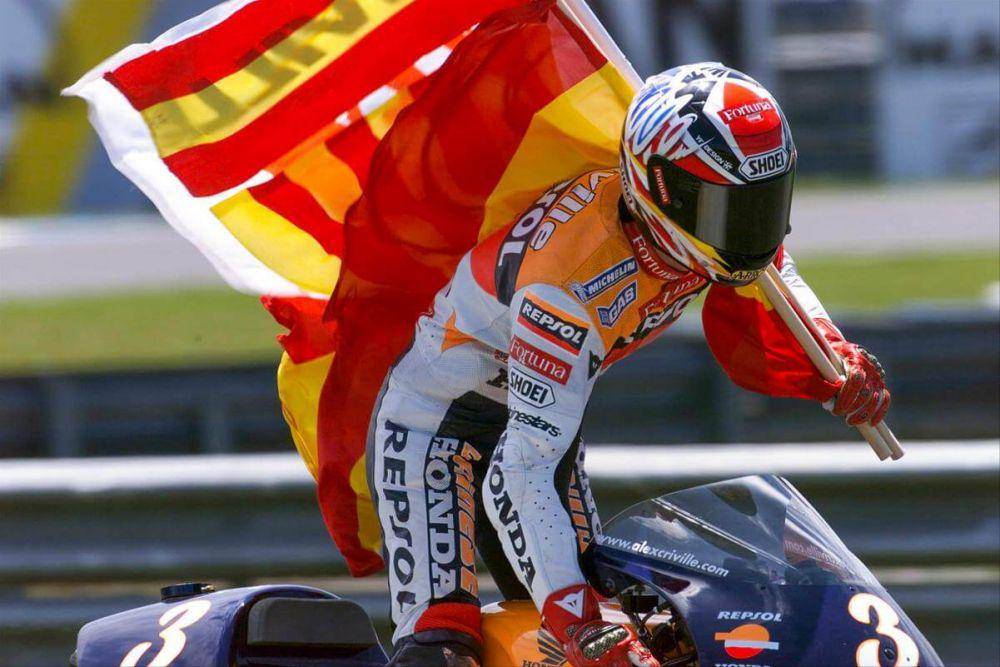 Alex Criville membawa bendera di atas Repsol Honda. (motogp.com)