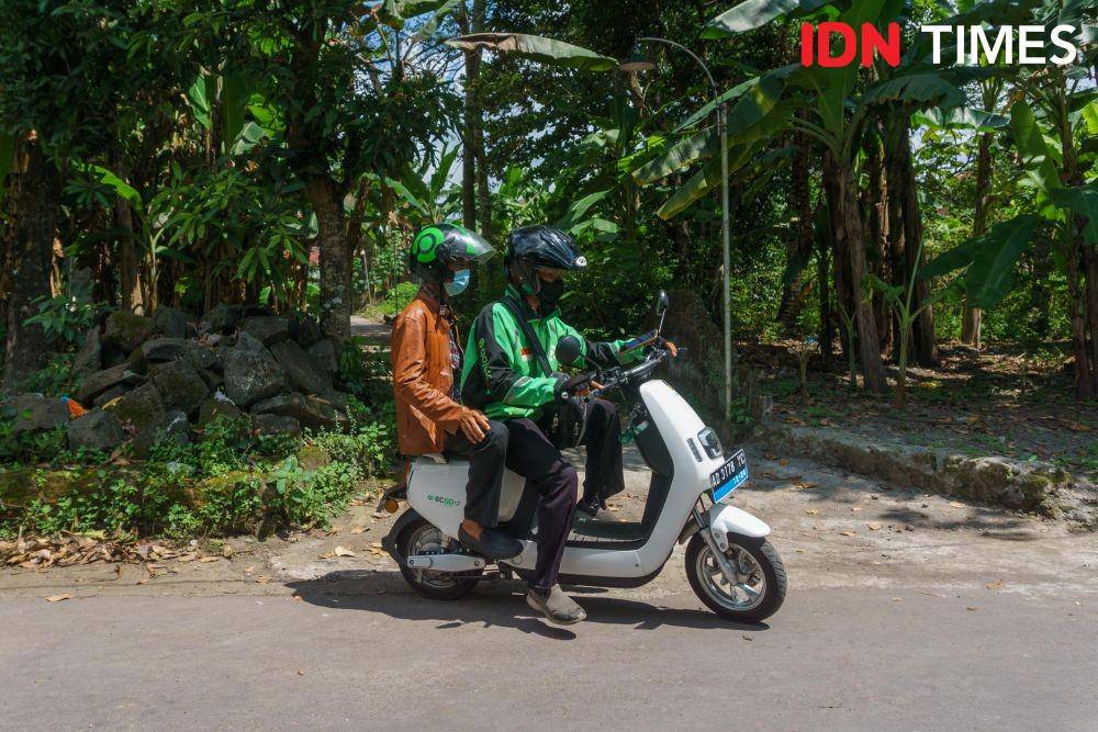 Anis Ramadhani (27), driver ojek online mengantarkan penumpang ke daerah Sambisari, Sleman, Daerah Istimewa Yogyakarta menggunakan motor listrik. (IDN Times/Dhana Kencana)