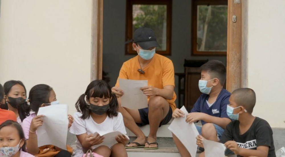 Potret Gede Andika bersama anak-anak Desa Pemuteran saat mengikuti Kreasi Edukasi Bahasa dan Literasi Lingkungan (KREDIBALI). (dok.Youtube/Jejak Literasi Bali)