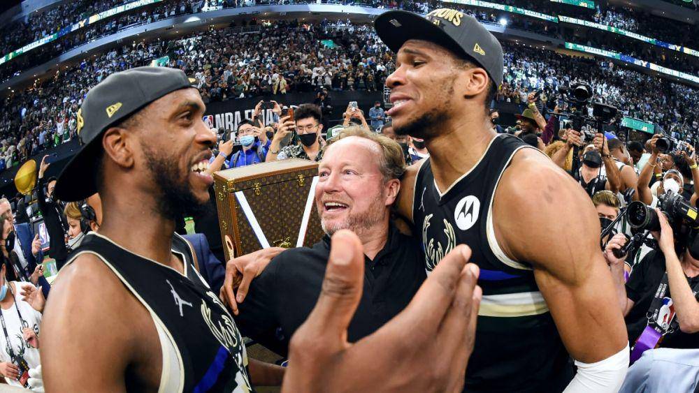 Khris Middleton, Mike Budenholzer, dan Giannis Antetokounmpo di tengah kerumunan setelah Milwaukee Bucks sukses menjadi juara NBA 2021. (nba.com)