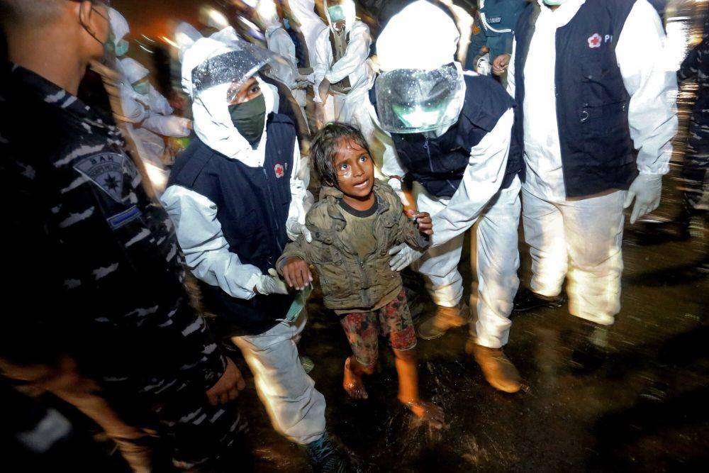 Petugas Palang Merah Indonesia (PMI) Lhokseumawe membawa anak pengungsi etnis Rohingya saat proses evakuasi di Pelabuhan ASEAN, Krueng Geukuh, Aceh Utara, Aceh, Jumat (31/12/2021). (ANTARA FOTO/Syifa Yulinnas)