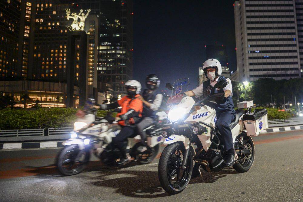 Gubernur DKI Jakarta Anies Baswedan (kanan) mengendarai kendaraan Dinas Perhubungan DKI Jakarta saat melakukan patroli pada pemberlakuan Crowd Free Night di Bundaran Hotel Indonesia, Jakarta, Sabtu (1/1/2022) (ANTARA FOTO/M Risyal Hidayat)
