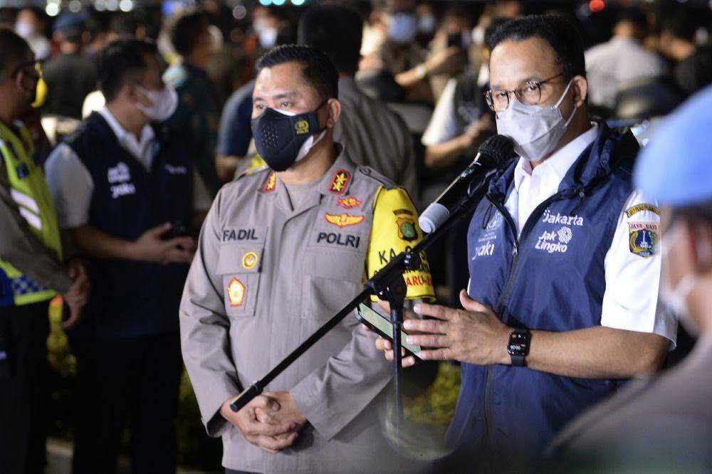 Gubernur DKI Jakarta Anies Baswedan (kanan) didampingi Kapolda Metro Jaya Irjen Pol Mohammad Fadil Imran (kiri) memberi keterangan pers pada awak media saat pemberlakuan Crowd Free Night di Bundaran Hotel Indonesia, Jakarta, Sabtu (1/1/2022) (ANTARA FOTO/M Risyal Hidayat)